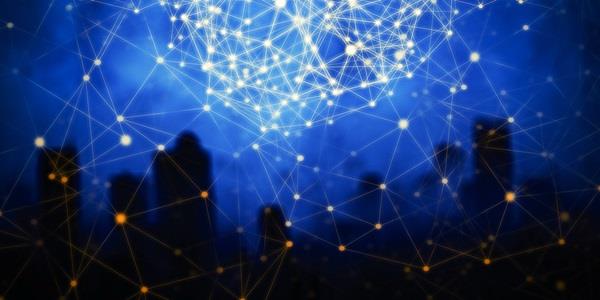 Image of a network of nodes and lines displayed over a blue background at the top of the image and a black silhouette of a city in the bottom of the image