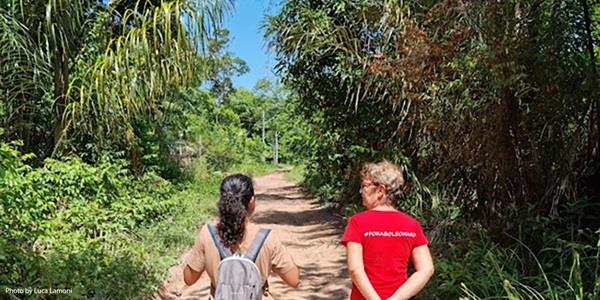 Two people walking on a path with trees