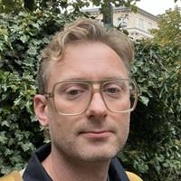 Headshot of Ask Greve against green background of ivy