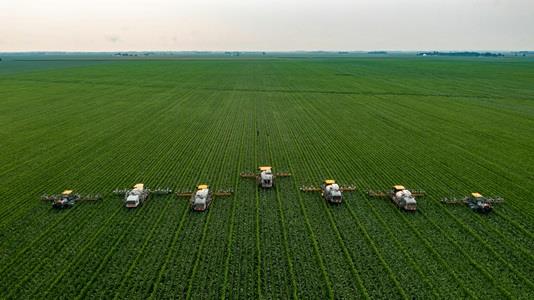 Aereal photo of 7 large machines detasseling Corn in Central Illinois
