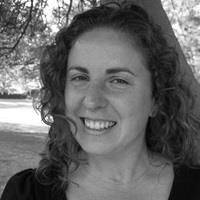 black and white headshot of woman against backdrop of nature